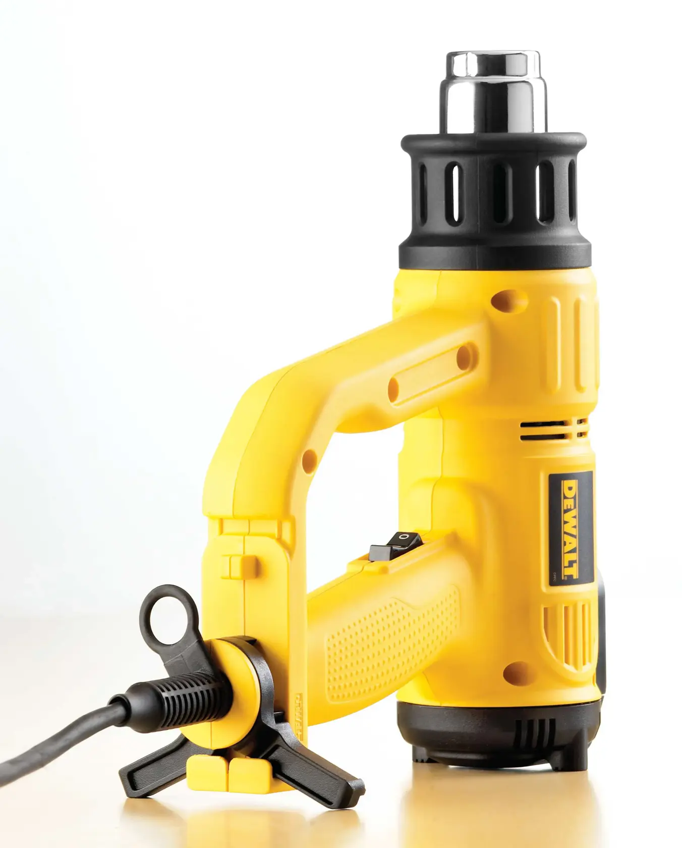 DEWALT D26414 yellow heat gun tool with a black nozzle and cord, placed on a light surface.