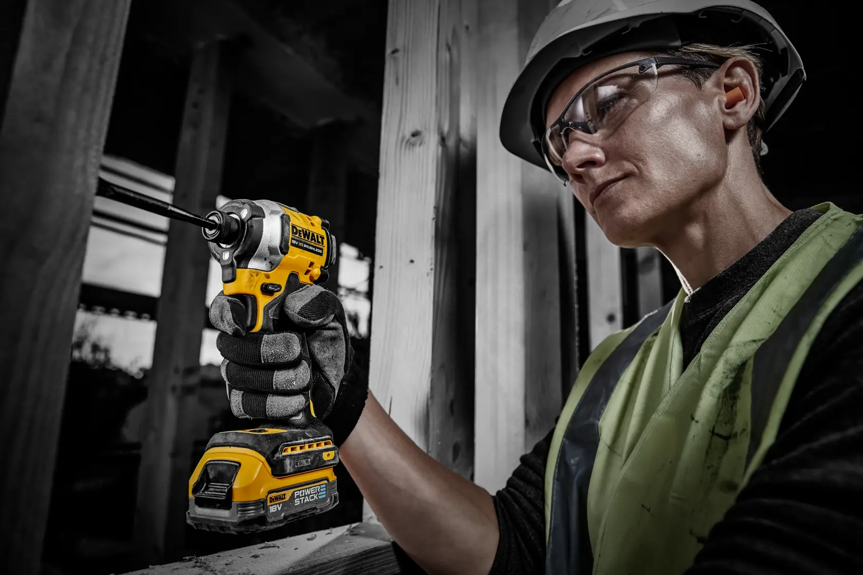 Arbeiter nutzt DEWALT Werkzeug mit DCBP034 Akku auf Baustelle, Gesicht aus Datenschutzgründen verpixelt.