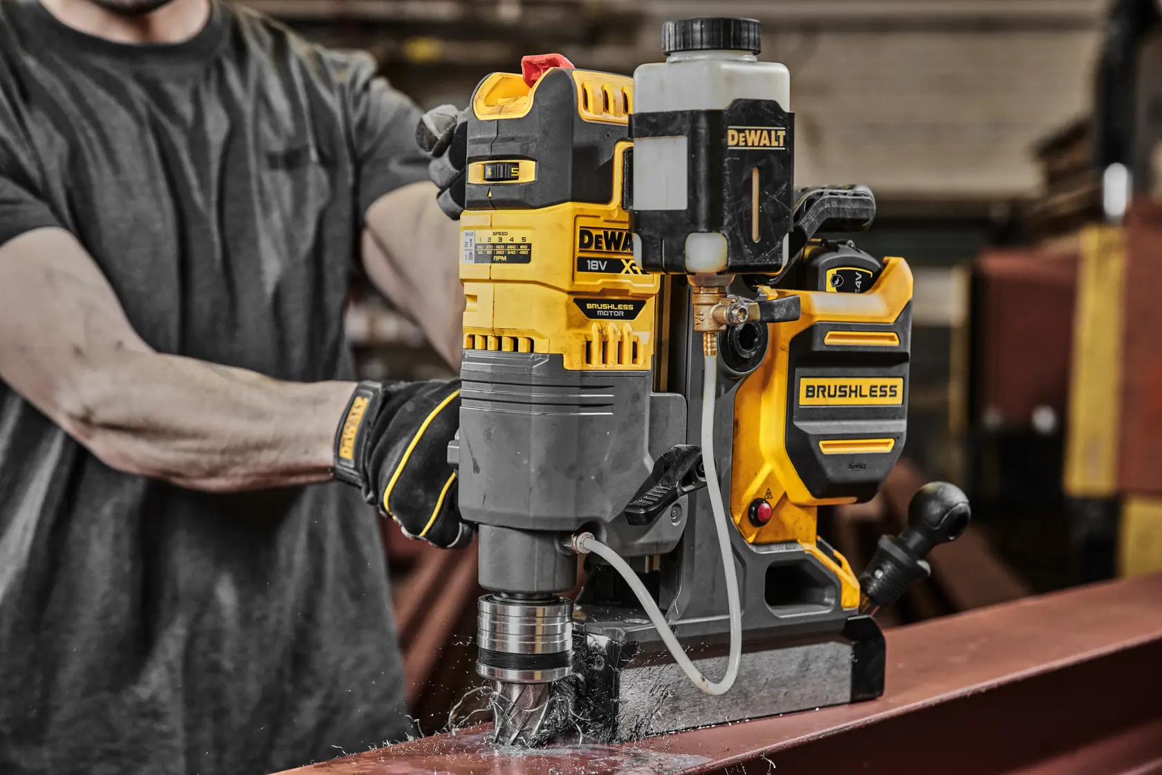 DEWALT bürstenlose Magnetbohrmaschine bohrt Loch in Stahlträger in industrieller Werkstatt.