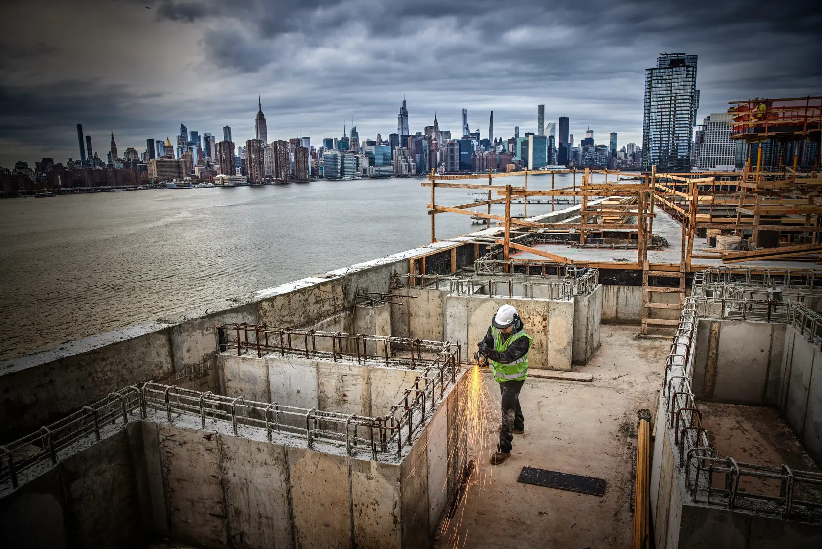 Photo of DEWALT DCG405P2-IN, DCG405P2, DCG405P2-GB grinder used at construction site, worker cutting rebar.