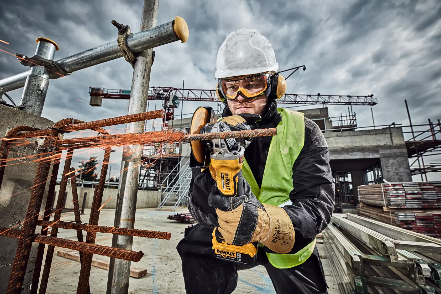 Photo of worker using DeWalt grinder on rebar, construction site. SKUs: DCG406N, DCZ409P2-XE, DCG406N-XJ, DCG406NT