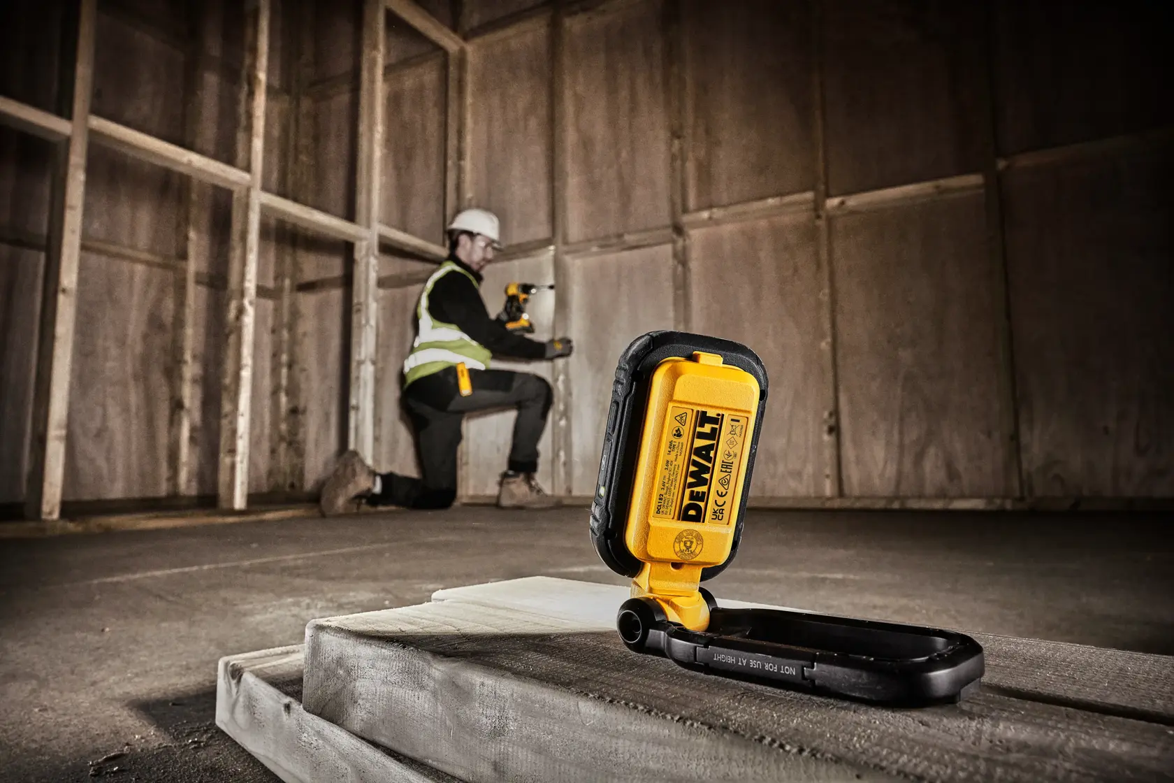 A DEWALT DCL182 portable LED work light with a rugged black and yellow casing, adjustable stand, and multiple LED bulbs, shown against a white background.