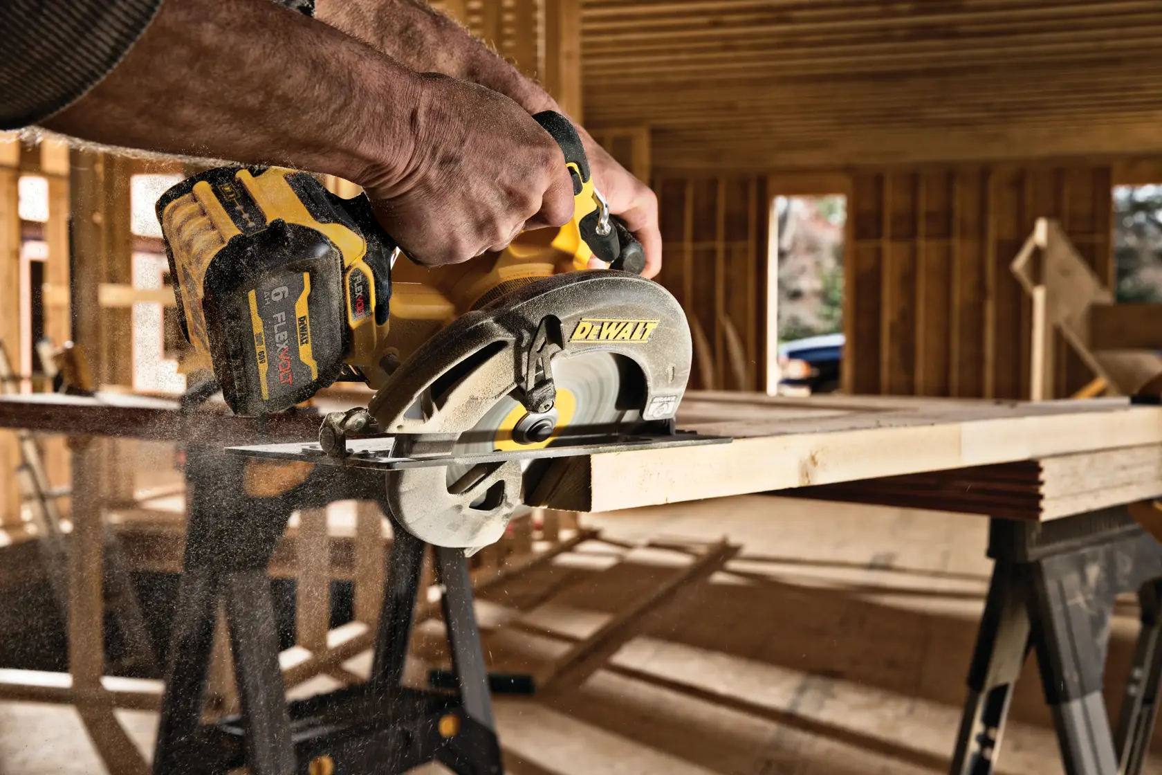 DEWALT cordless circular saw cutting wood on a construction site. Dust is seen around the blade.