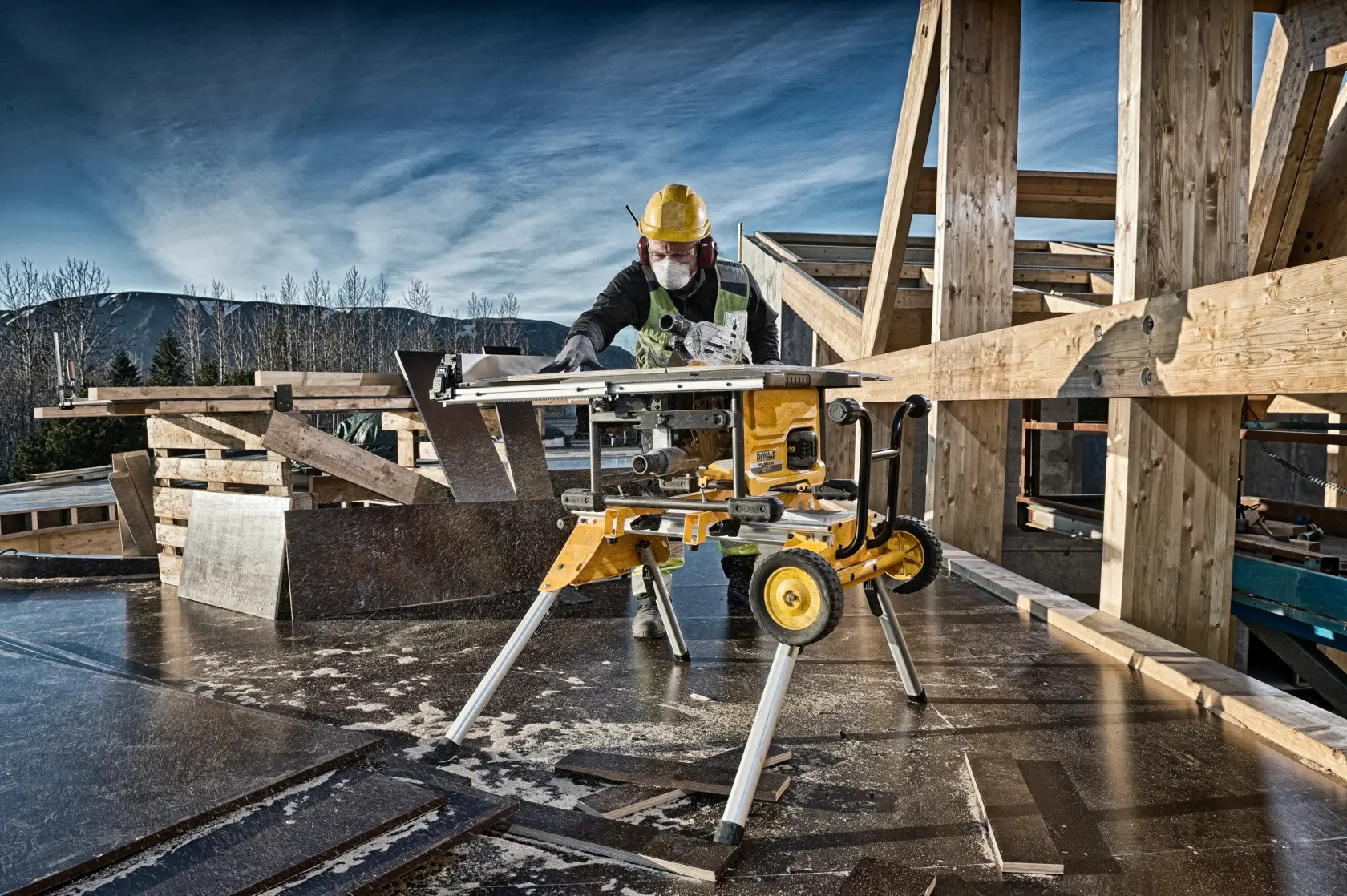 A DEWALT table saw (model DCS7485) on a construction site, being operated by a person wearing safety gear, including a