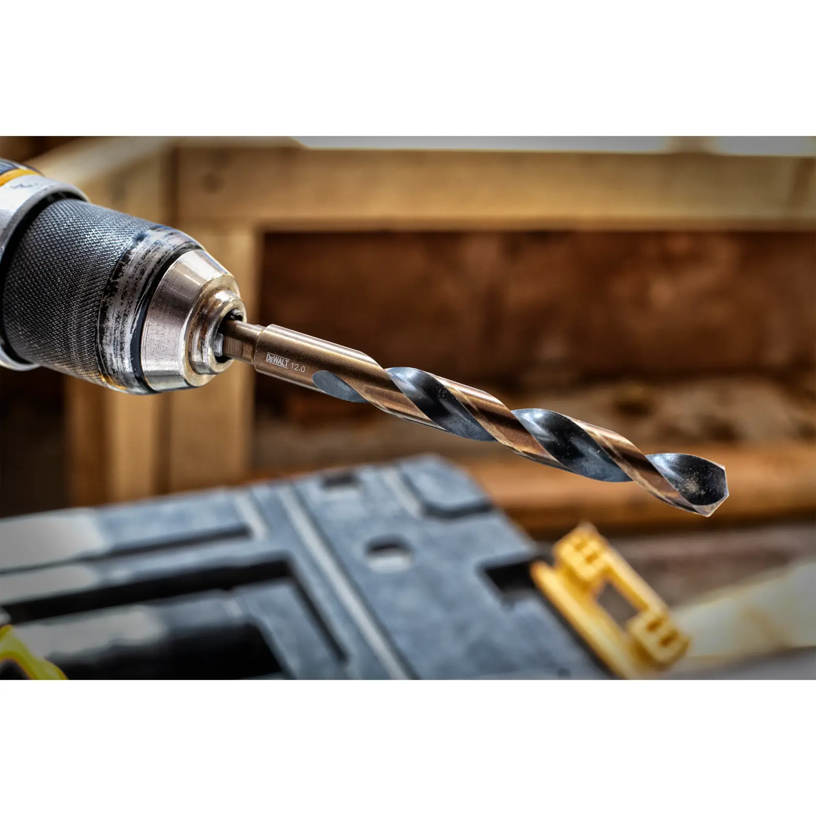 Close-up of a DEWALT drill bit attached to a power drill, shown in a workshop setting.