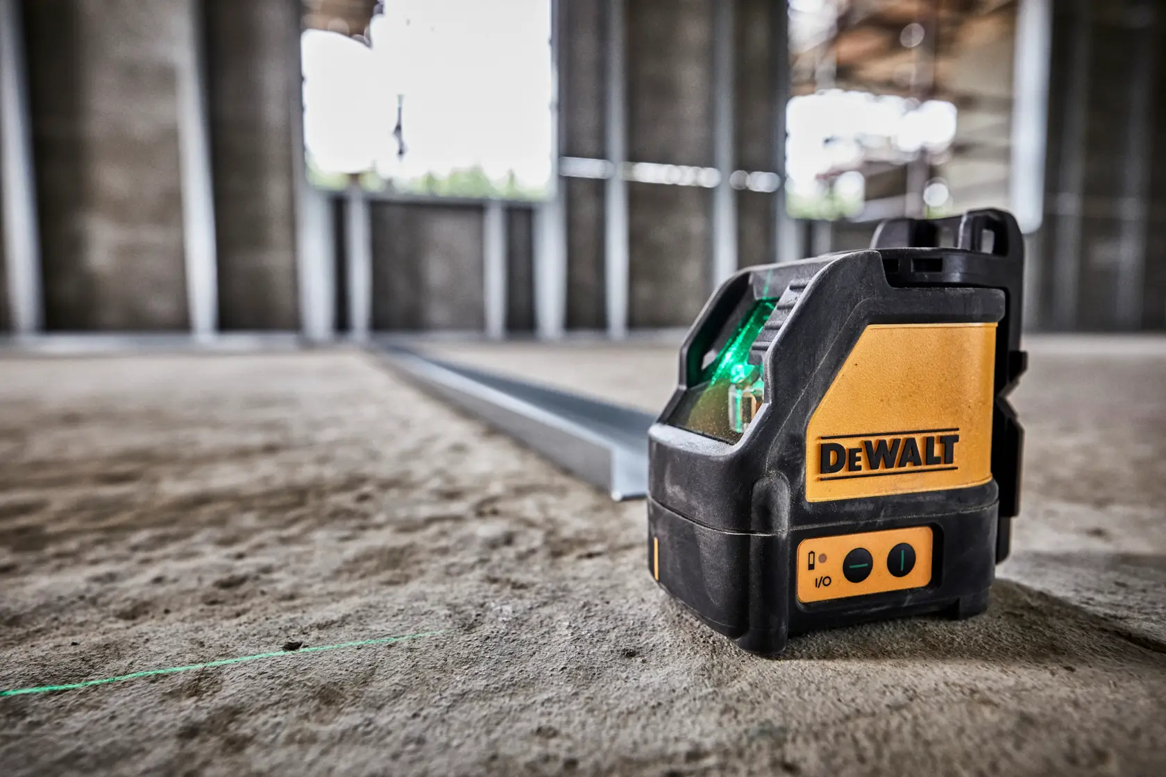A DEWALT DW088CG laser line generator with a sturdy black and yellow casing, visible control panel and warning stickers, used for precise alignment in photography and construction applications.
