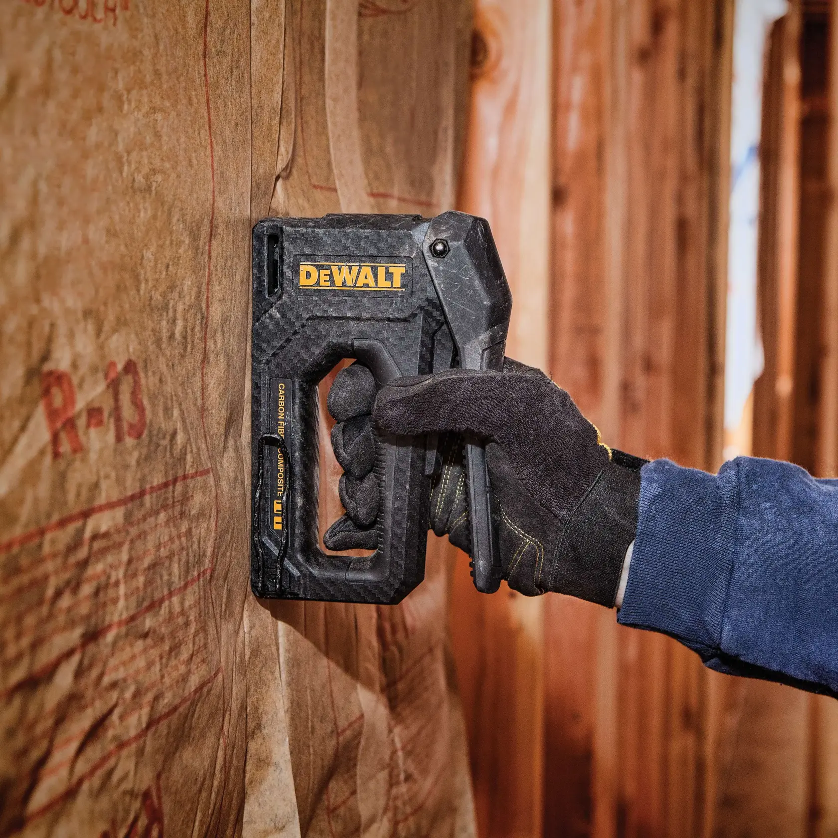 A DEWALT carbon fiber composite hand stapler with a black and yellow design, featuring an ergonomic handle and compact construction.